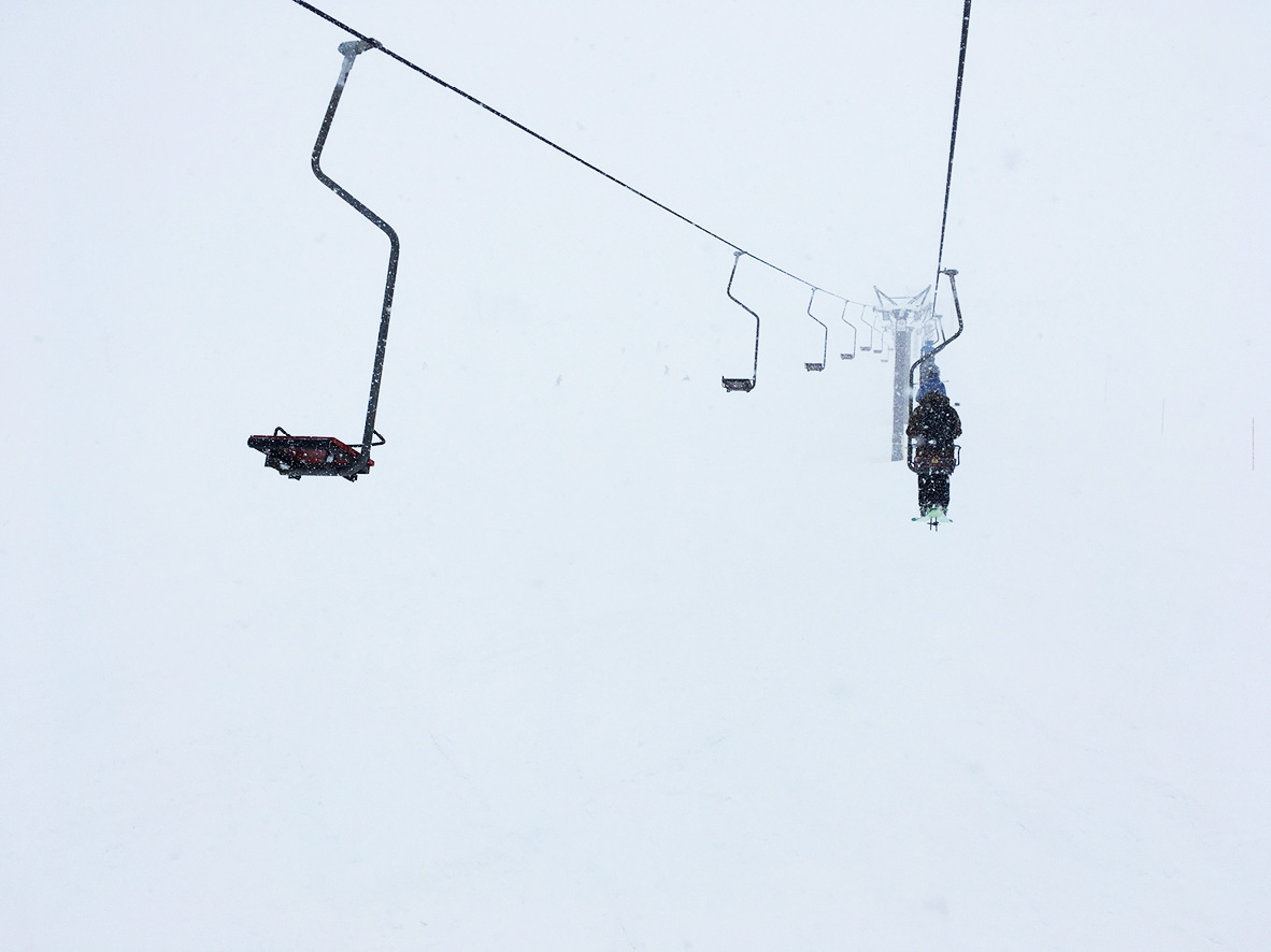 A skier rides on a single-person chairlift in Niseko, Japan.